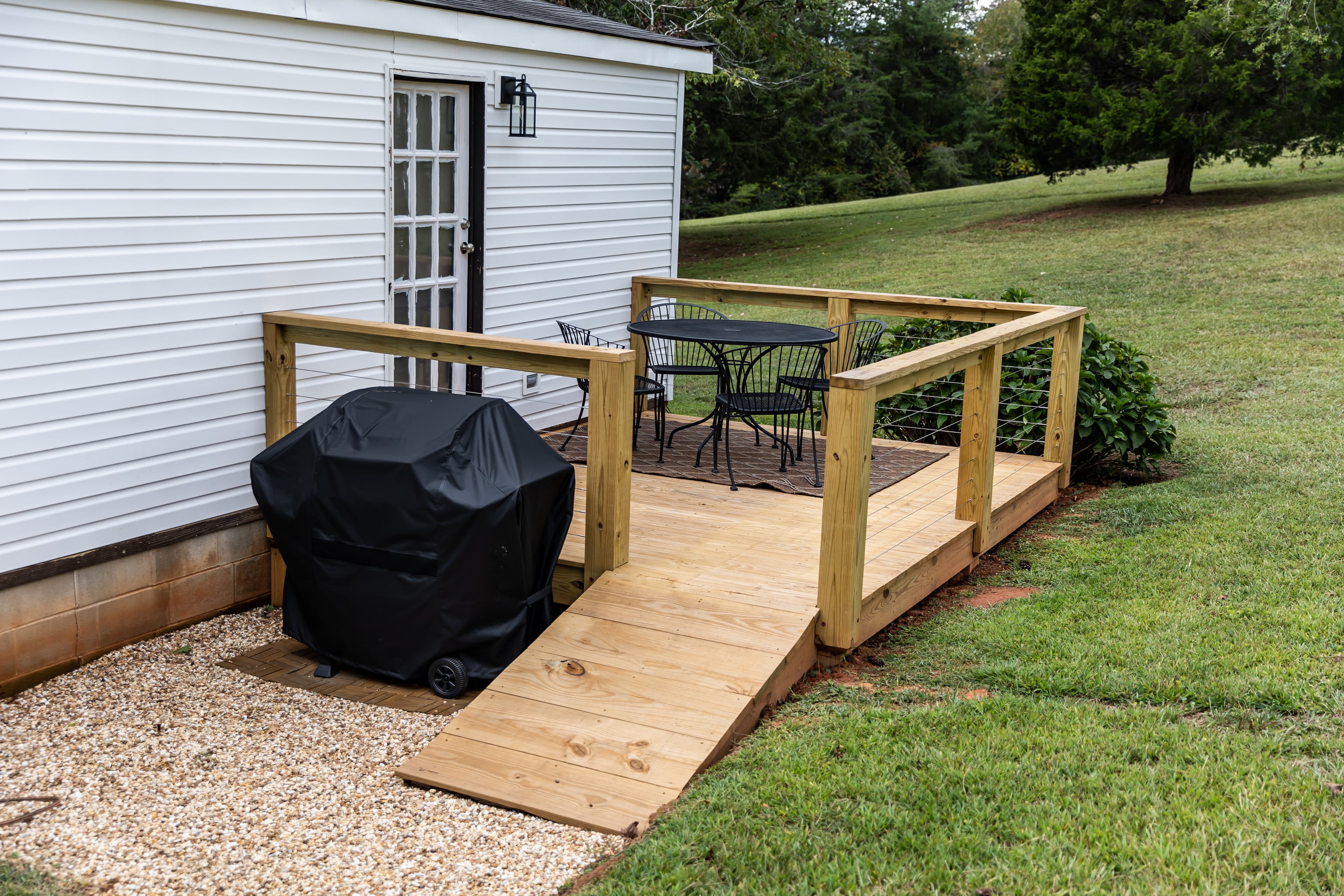 Wooden deck with seating for four and BBQ grill