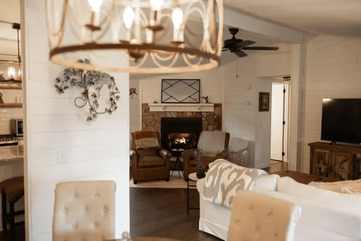 A cozy living room featuring comfortable seating, a stone fireplace, and rustic decor.