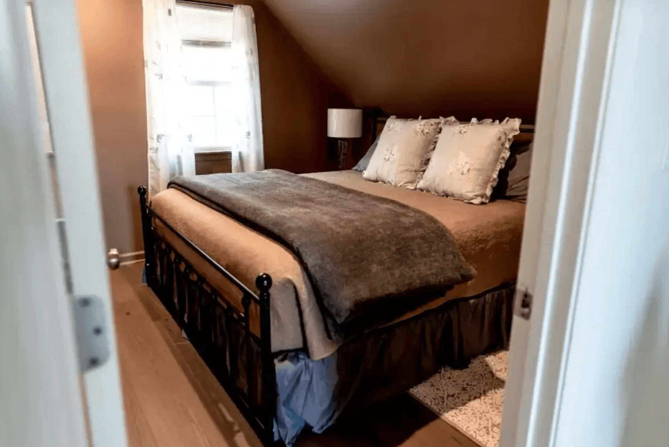 Cozy bedroom with a brown accent wall, a metal bed frame, and soft bedding.